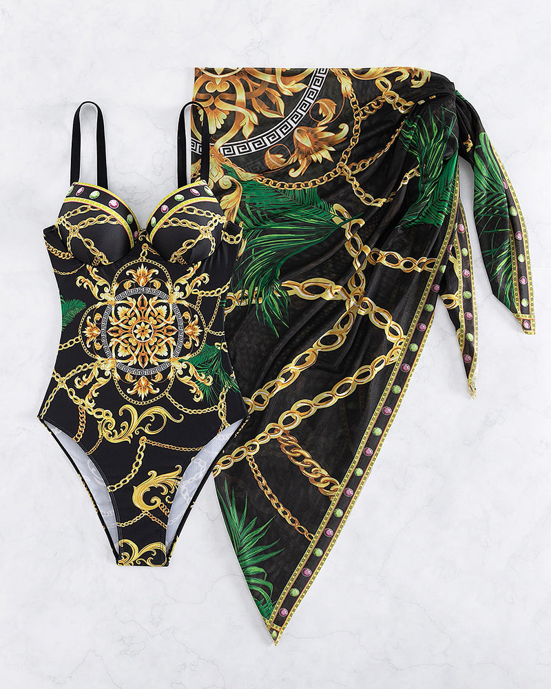 Aitana - maillot une pièce noir à motifs dorés et verts avec paréo assorti présenté à plat