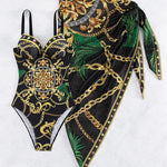 Aitana - maillot une pièce noir à motifs dorés et verts avec paréo assorti présenté à plat